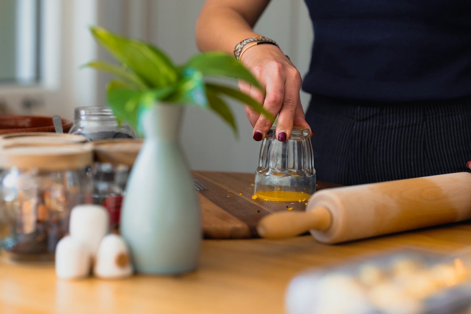 Hands plating food on a kitchen counter in natural window light